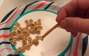 Pincer and/or tripod grasp to pick up cheerios with a pretzel stick